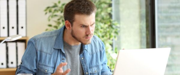 time-warner-lags A man frustrated with his laptop due to slow internet speeds.