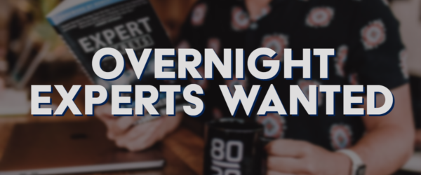 BSN-Blog-1.10.20 Overnight Experts Wanted Banner - Featuring a man holding a book and a coffee mug next to his laptop
