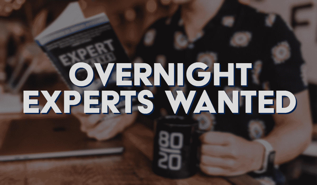 Overnight Experts Wanted Banner - Featuring a man holding a book and a coffee mug next to his laptop