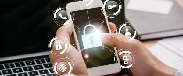 Hands holding a phone showing cybersecurity icons, representing Wilmington IT security measures.