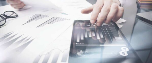 Industries That Need Managed Cyber-Solutions A person analyzing data on a tablet optimized and protected by Myrtle Beach managed IT services.