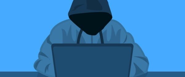 Sinister man sitting at a laptop.