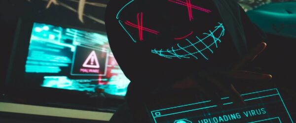 A hooded figure with an LED mask hacking to try and breach network security in Wilmington NC.