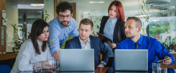 IT-Management-In-2025-Break-Fix-vs-Managed-ITs A Wilmington IT management team helping a client with a laptop in an office.