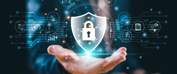 A businessman is holding out his hand to reveal a lock and shield icon with a circuit board pattern.