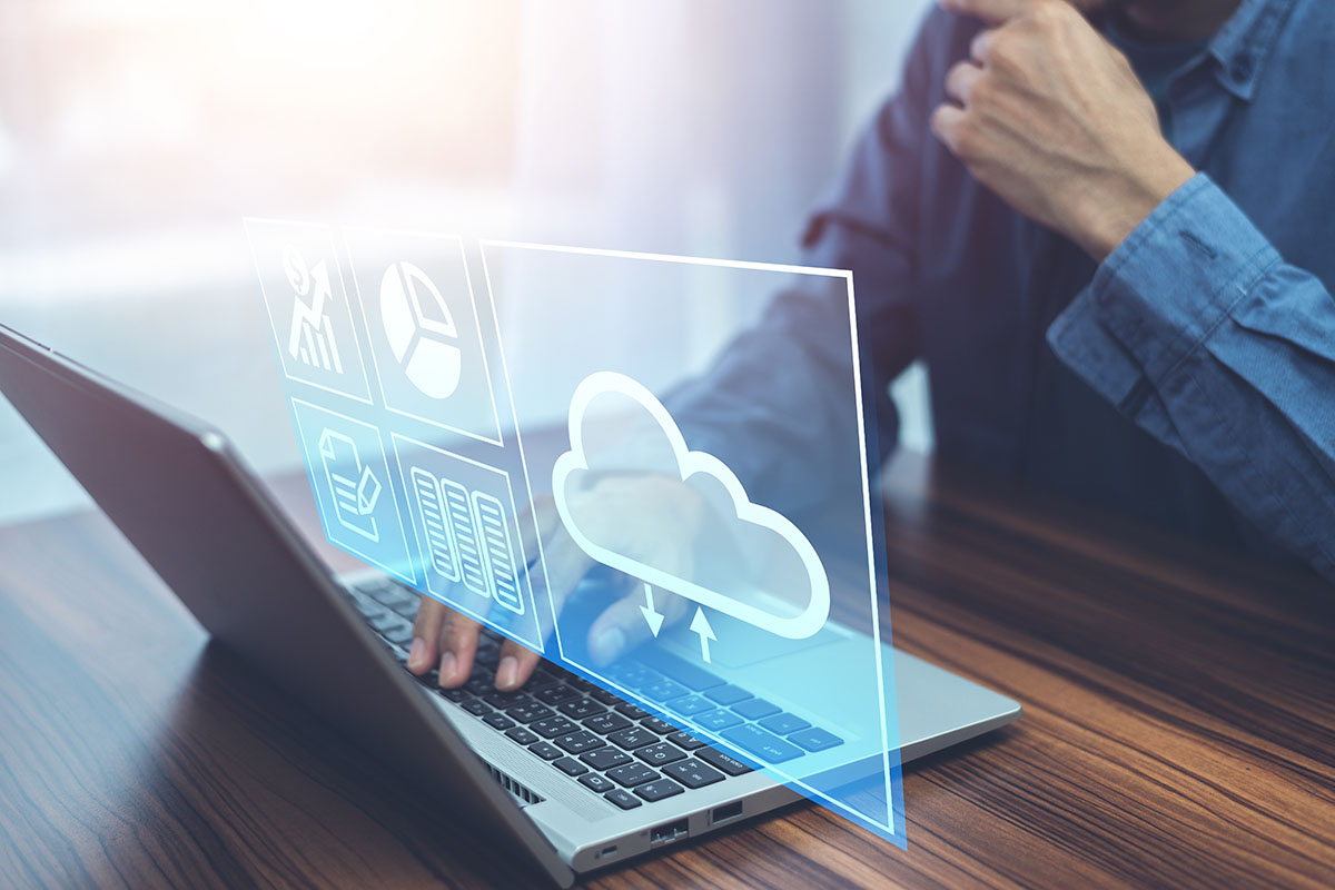 A person using a laptop with a blue sky background, interacting with digital icons representing data analysis and cloud computing.