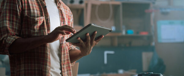 cybersecurity-for-furniture-manufacturers A man using a tablet in a furniture manufacturing plant.