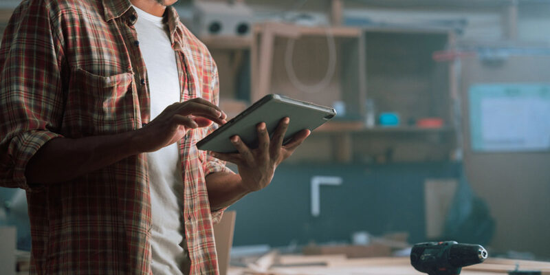 cybersecurity-for-furniture-manufacturers A man using a tablet in a furniture manufacturing plant.