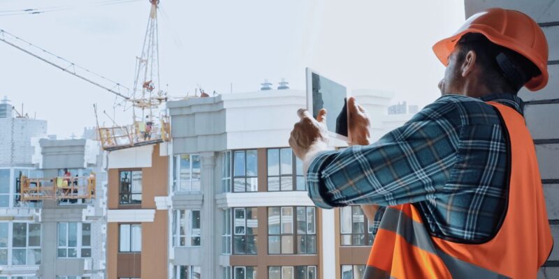 A construction worker using a tablet on a job site.