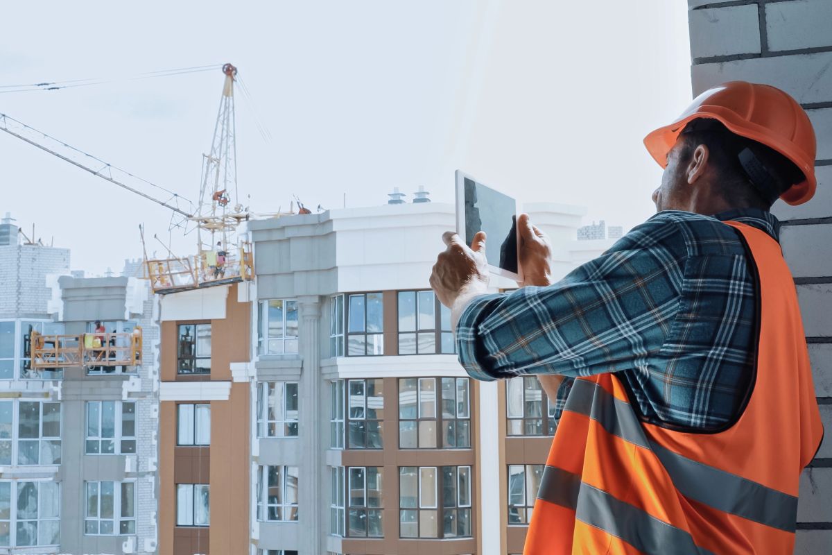 A construction worker using a tablet on a job site.