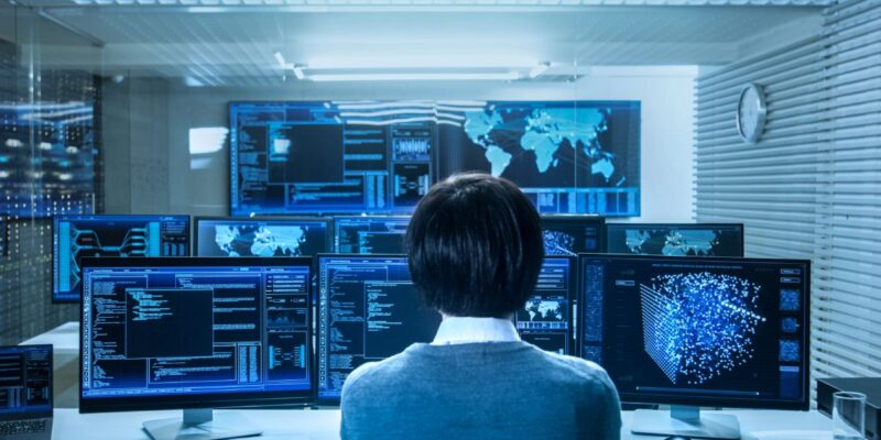 cybersecurity-threats-2026 A technician sitting in a remote support monitoring room.