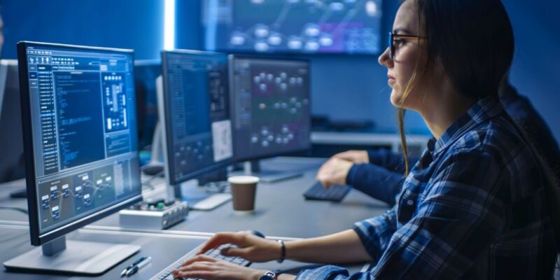 A woman using AI to improve cybersecurity on a client's network.