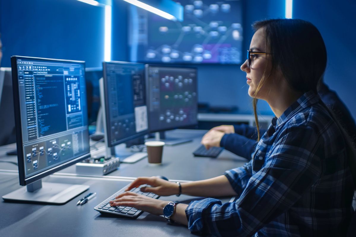 A woman using AI to improve cybersecurity on a client's network.