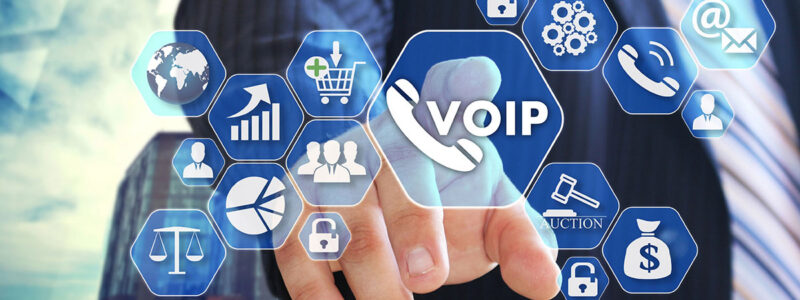 A businessman in a suit points towards a virtual touchscreen displaying various icons related to VoIP, communication, analytics, and online services.