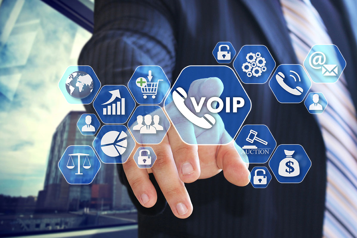 A businessman in a suit points towards a virtual touchscreen displaying various icons related to VoIP, communication, analytics, and online services.