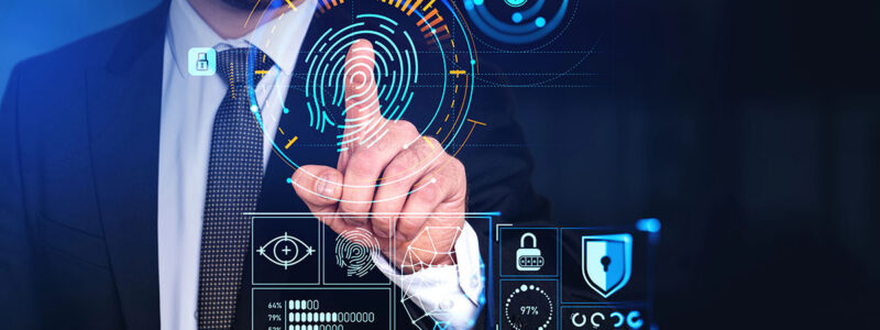 A businessman in a suit is interacting with a futuristic digital interface that displays biometric data and security icons, including a fingerprint, padlocks, and various statistics.
