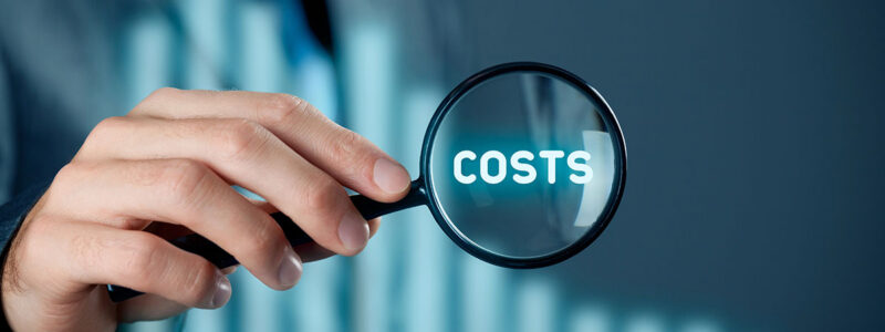 A person in a suit holds a magnifying glass over the word "COSTS," surrounded by a blurred background suggesting a business context.
