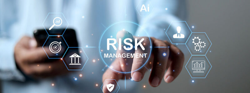 A person reaching out to tap a floating digital icon that reads "RISK MANAGEMENT" surrounded by business and technology symbols.