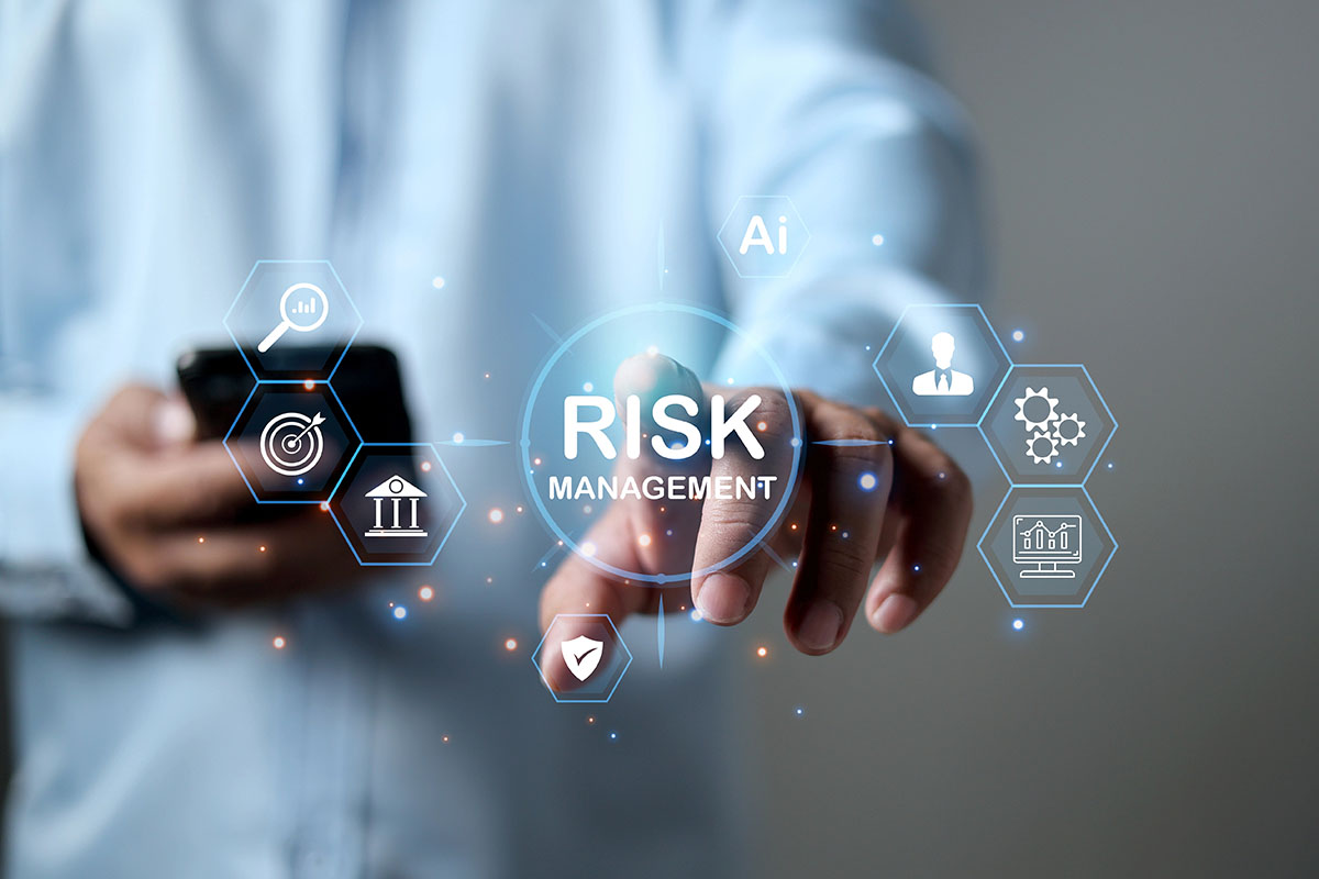 A person reaching out to tap a floating digital icon that reads "RISK MANAGEMENT" surrounded by business and technology symbols.