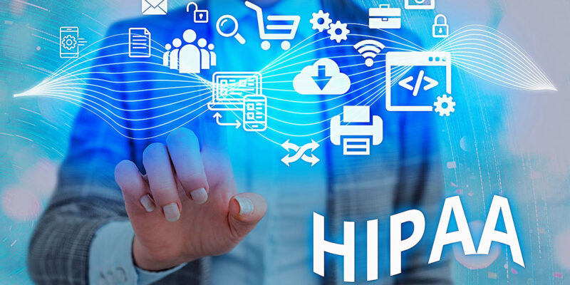 A professional reaching toward the word "HIPAA" surrounded by futuristic blue digital icons representing data, security, cloud storage, and communication.